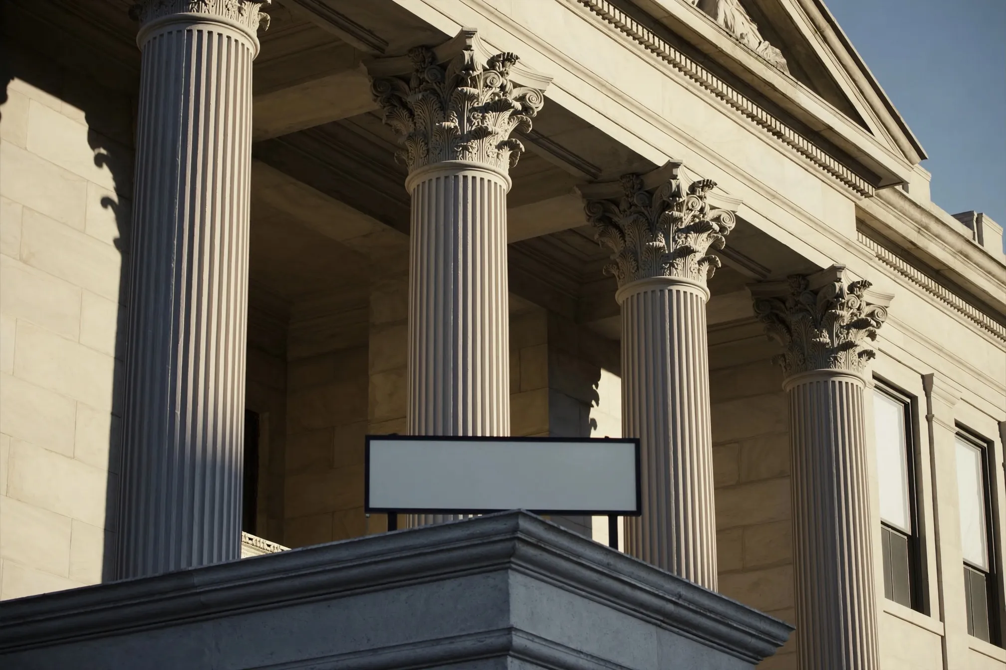 Tall classical limestone columns of a courthouse facade in soft morning light